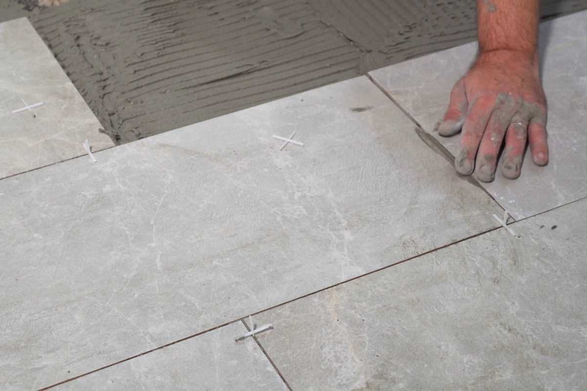 osoba postavlja pločice na pod